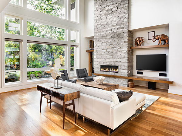 interior of a home living room with wood floors and a brick fireplace